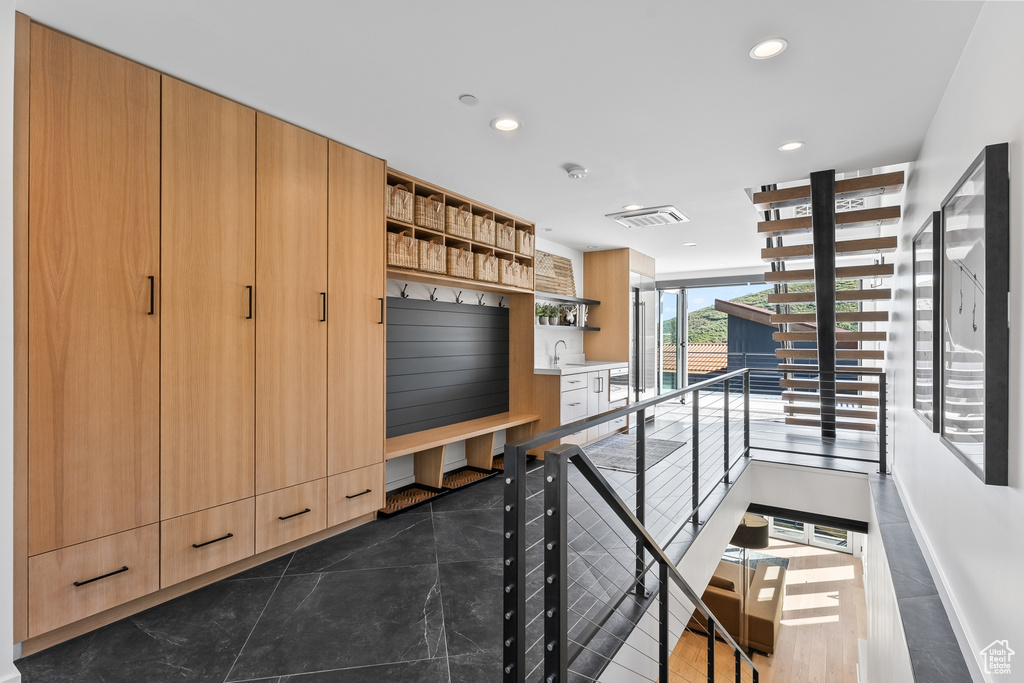 Hall featuring dark tile floors