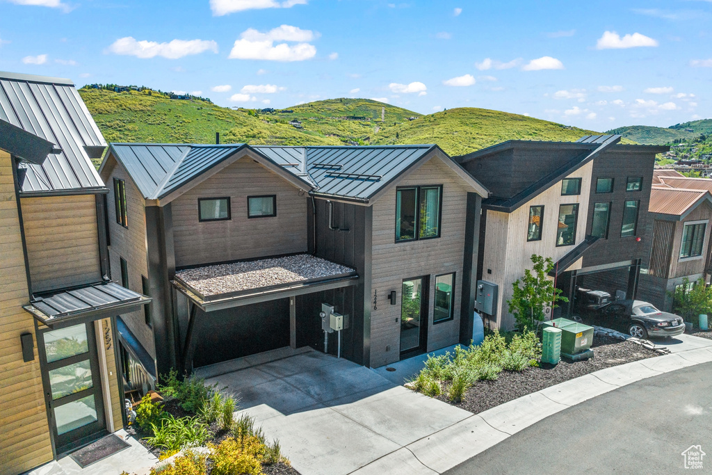 View of front facade with a garage and a mountain view