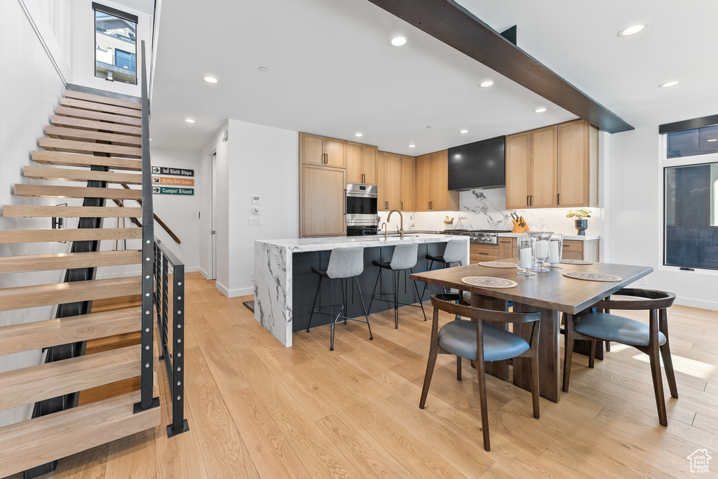 Dining area with light hardwood / wood-style floors and sink