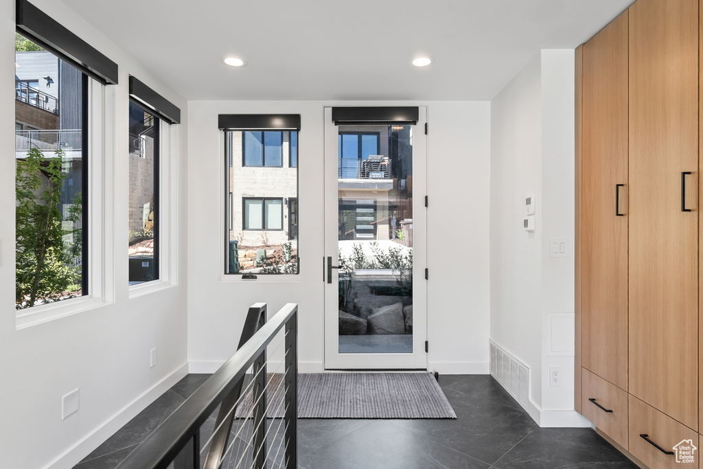 Doorway to outside with dark tile flooring and a healthy amount of sunlight