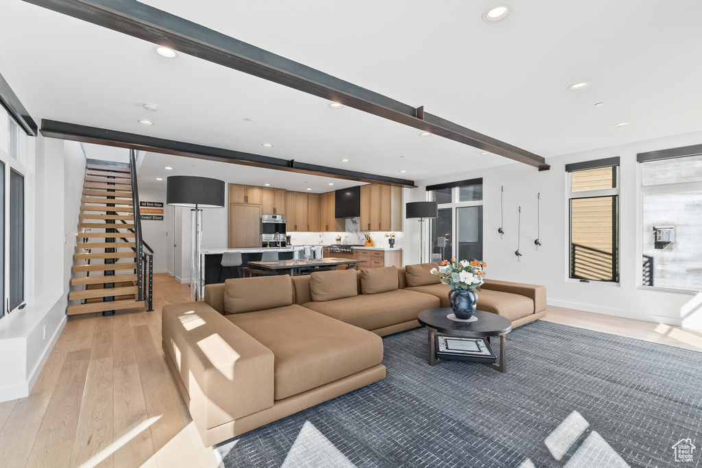 Living room with beam ceiling and light wood-type flooring