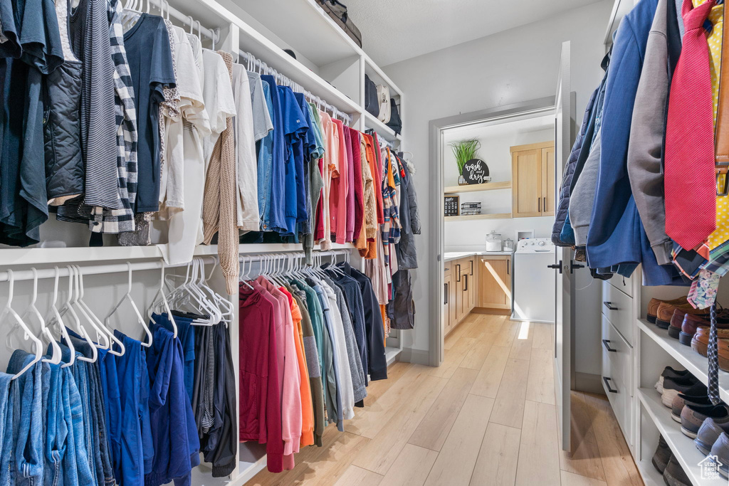 Walk in closet featuring light wood-type flooring and washer / dryer