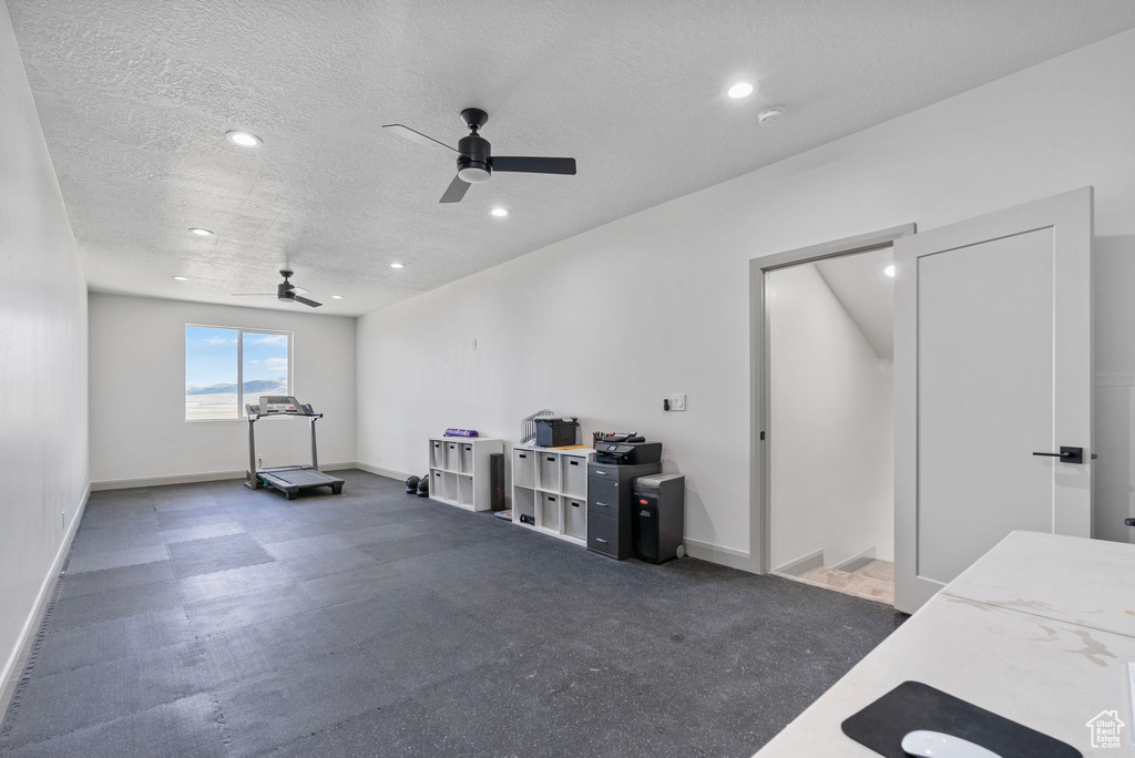 Interior space with a textured ceiling and ceiling fan