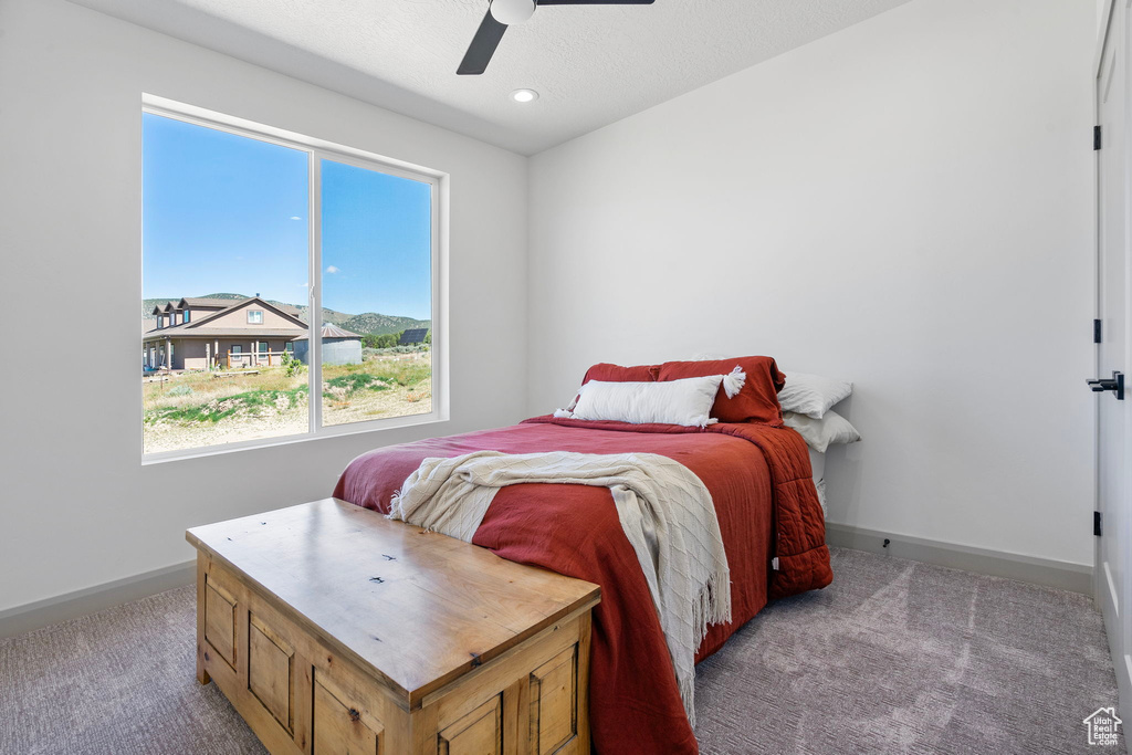 Carpeted bedroom featuring ceiling fan