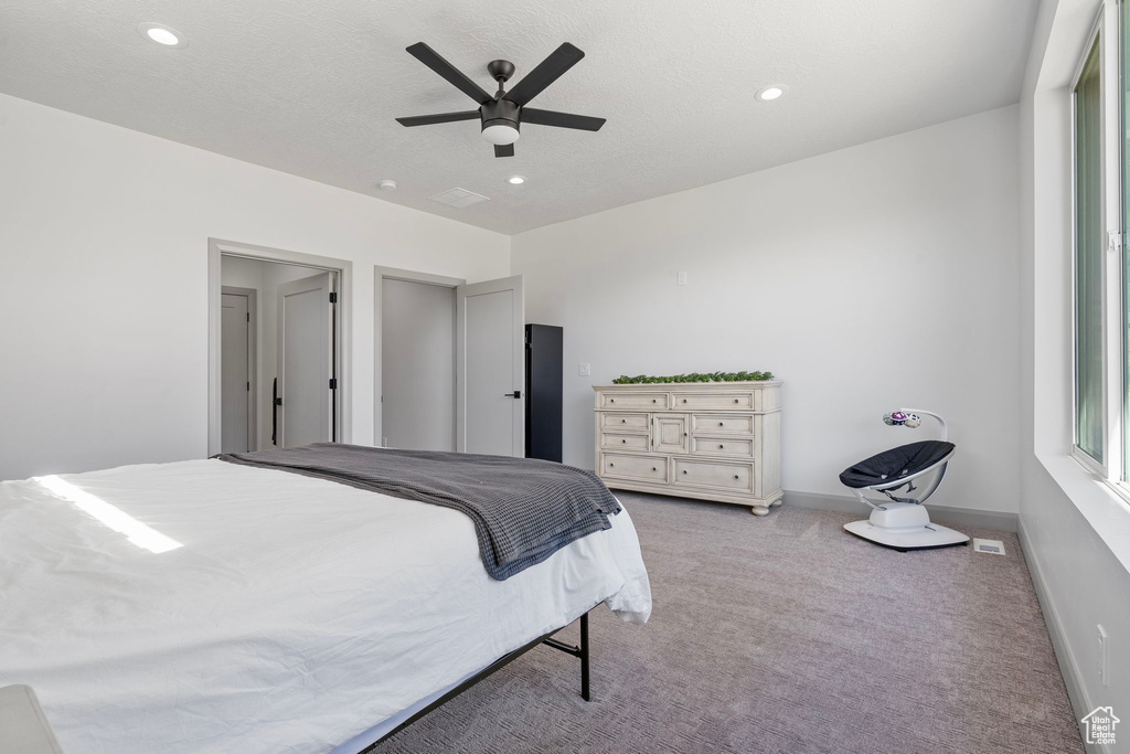 Carpeted bedroom featuring ceiling fan