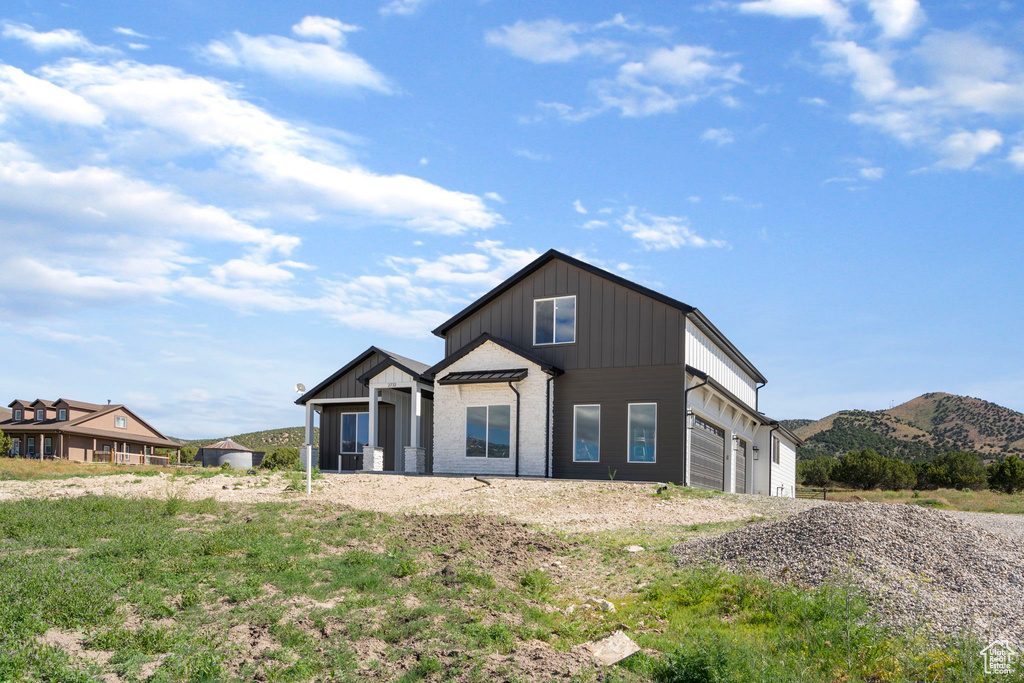 View of front of home with a garage and a mountain view