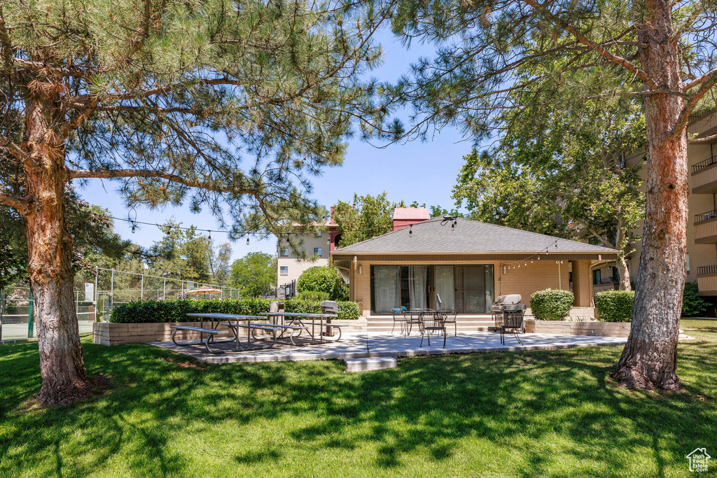 Rear view of house with a yard and a patio area