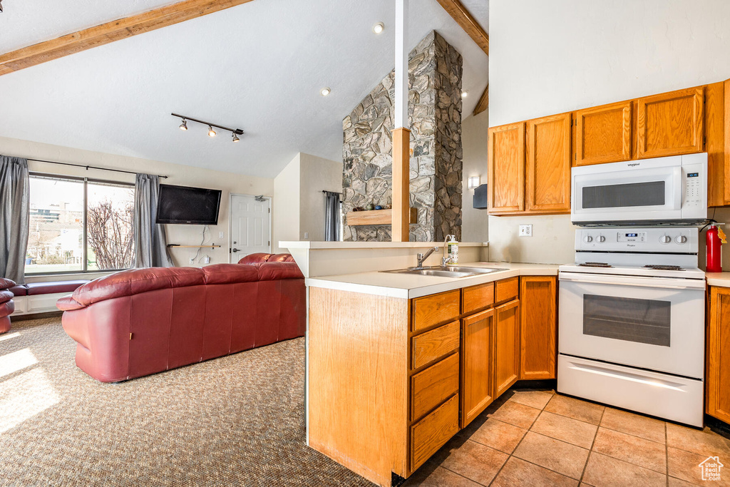 Kitchen with kitchen peninsula, white appliances, beamed ceiling, high vaulted ceiling, and sink