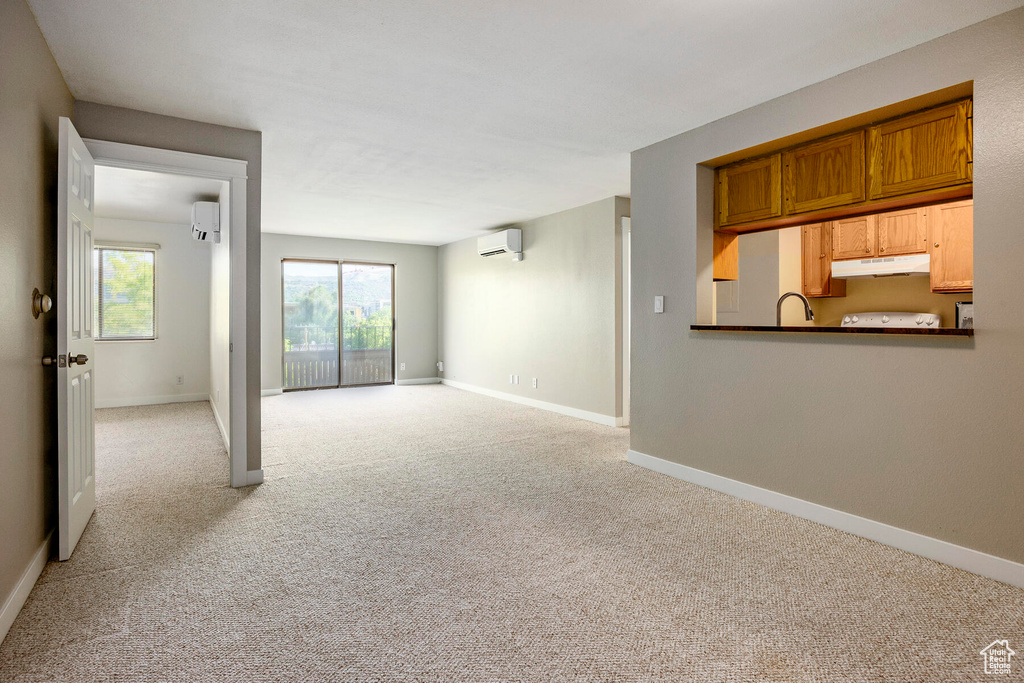 Interior space featuring sink, a wall unit AC, and light colored carpet