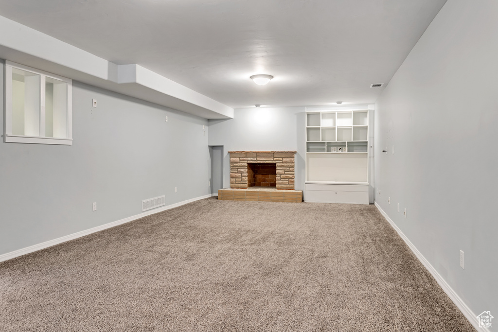 Unfurnished living room featuring a fireplace and carpet floors