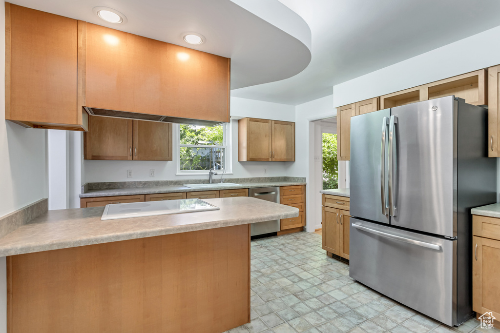 Kitchen with appliances with stainless steel finishes, a healthy amount of sunlight, sink, and light tile floors