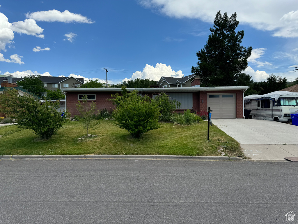 View of front facade featuring a garage and a front yard