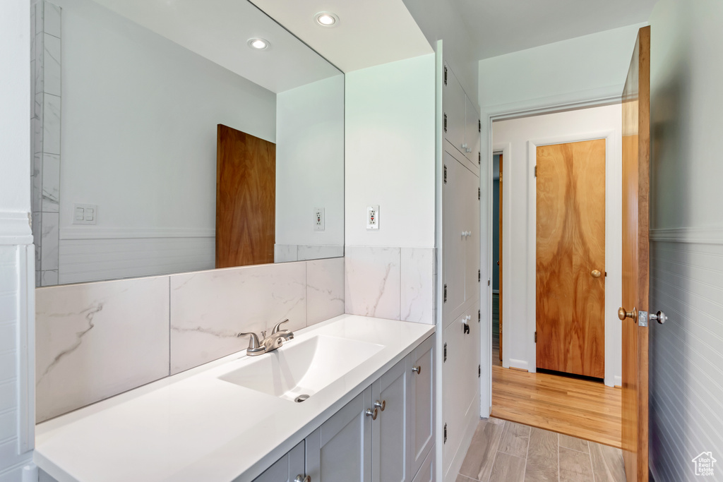 Bathroom featuring tile walls, hardwood / wood-style floors, and large vanity