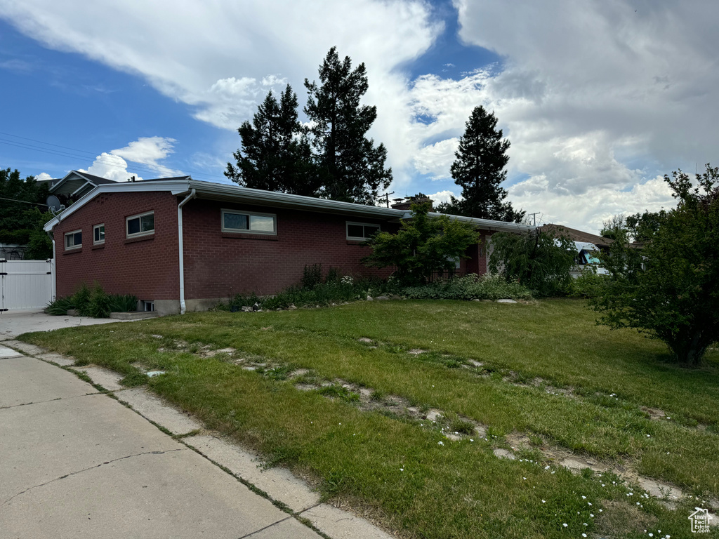 View of property exterior featuring a lawn