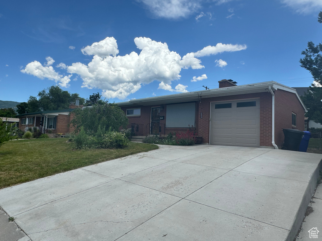 Ranch-style home with a garage and a front yard