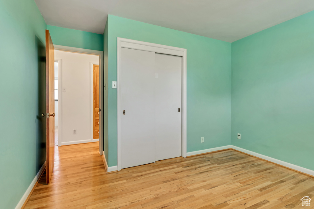 Unfurnished bedroom with light hardwood / wood-style floors and a closet