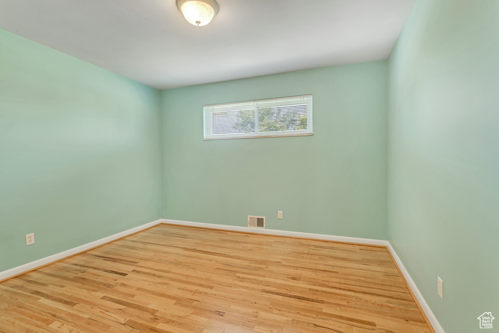 Empty room with hardwood / wood-style flooring