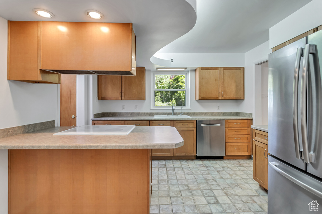 Kitchen featuring sink, kitchen peninsula, light tile floors, and appliances with stainless steel finishes