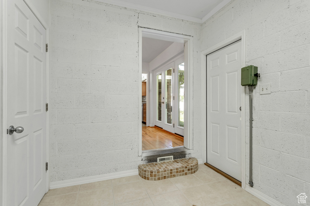 Tiled entrance foyer with crown molding