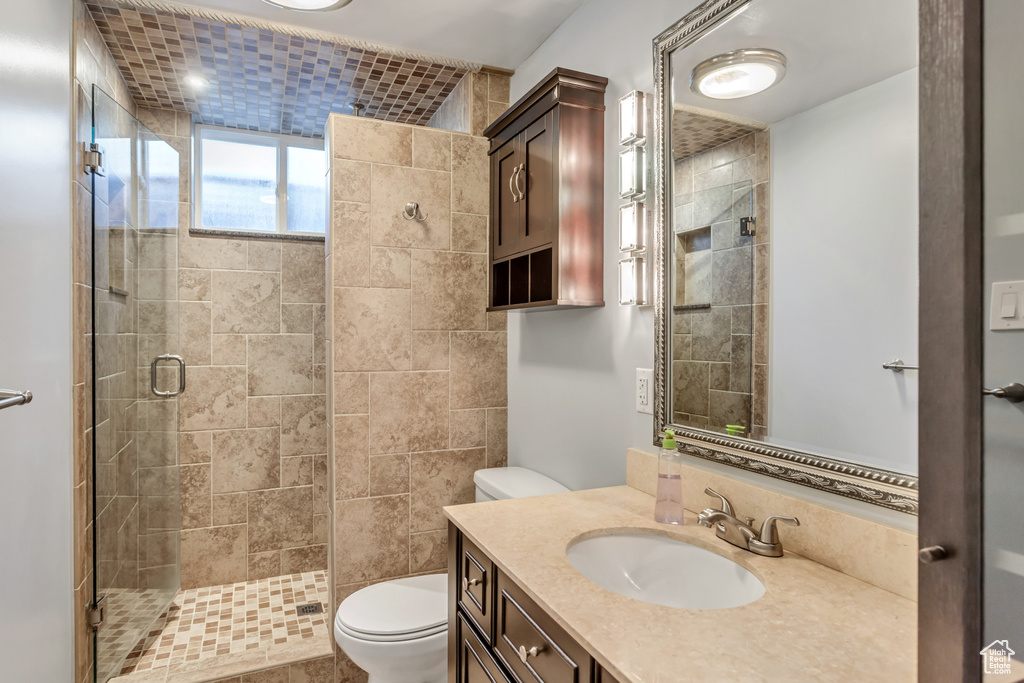 Bathroom with walk in shower, tile walls, toilet, and large vanity