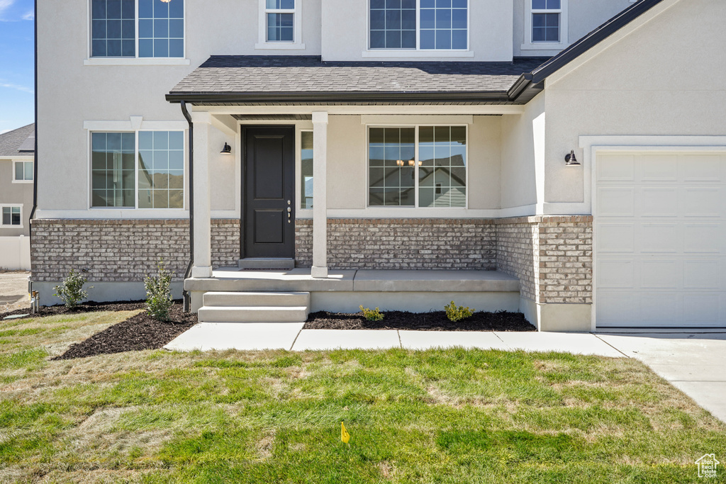 Property entrance with a yard and a garage