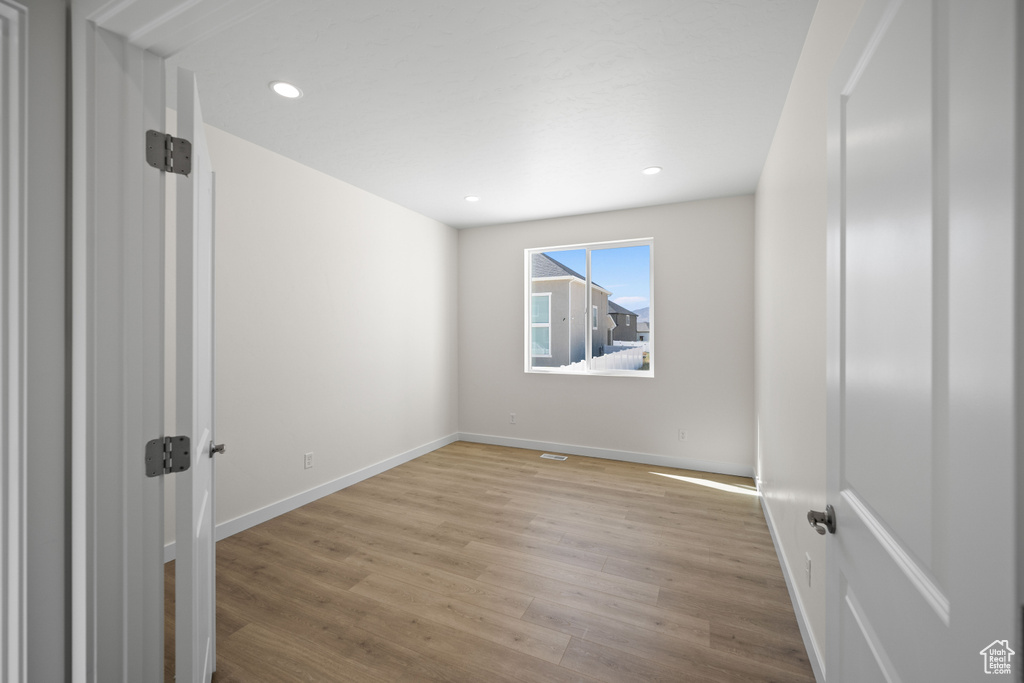 Empty room with light hardwood / wood-style flooring