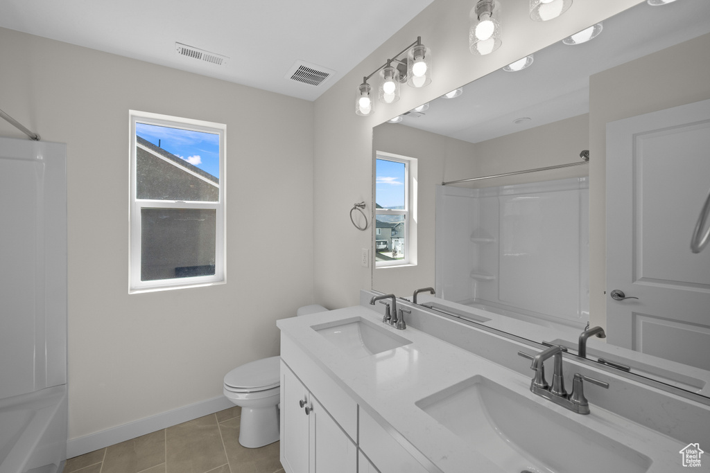 Full bathroom featuring shower / bath combination, tile patterned floors, vanity, and toilet