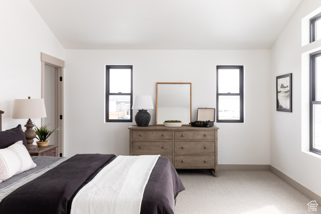 Bedroom with light carpet and vaulted ceiling