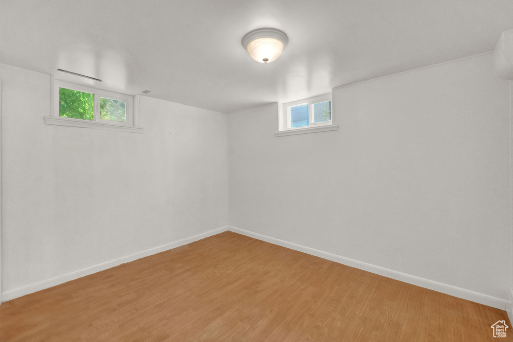 Basement with light wood-type flooring