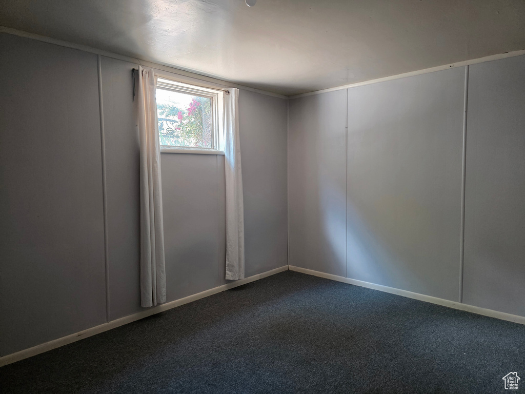 Unfurnished room with dark colored carpet