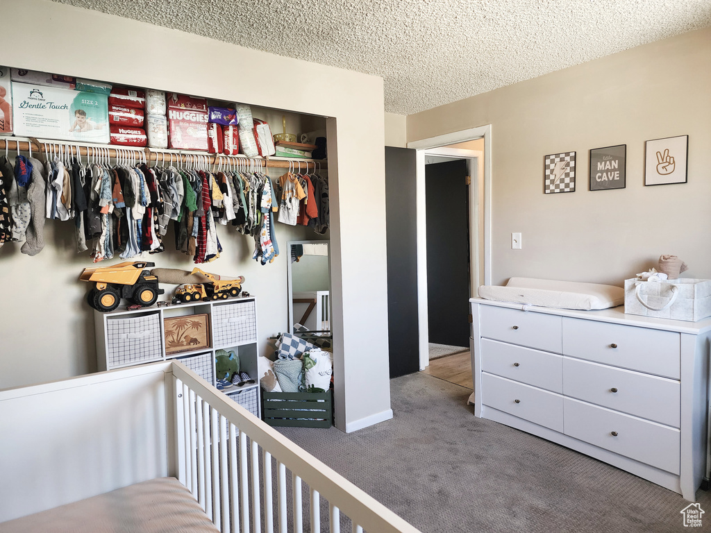 Carpeted bedroom with a closet and a textured ceiling