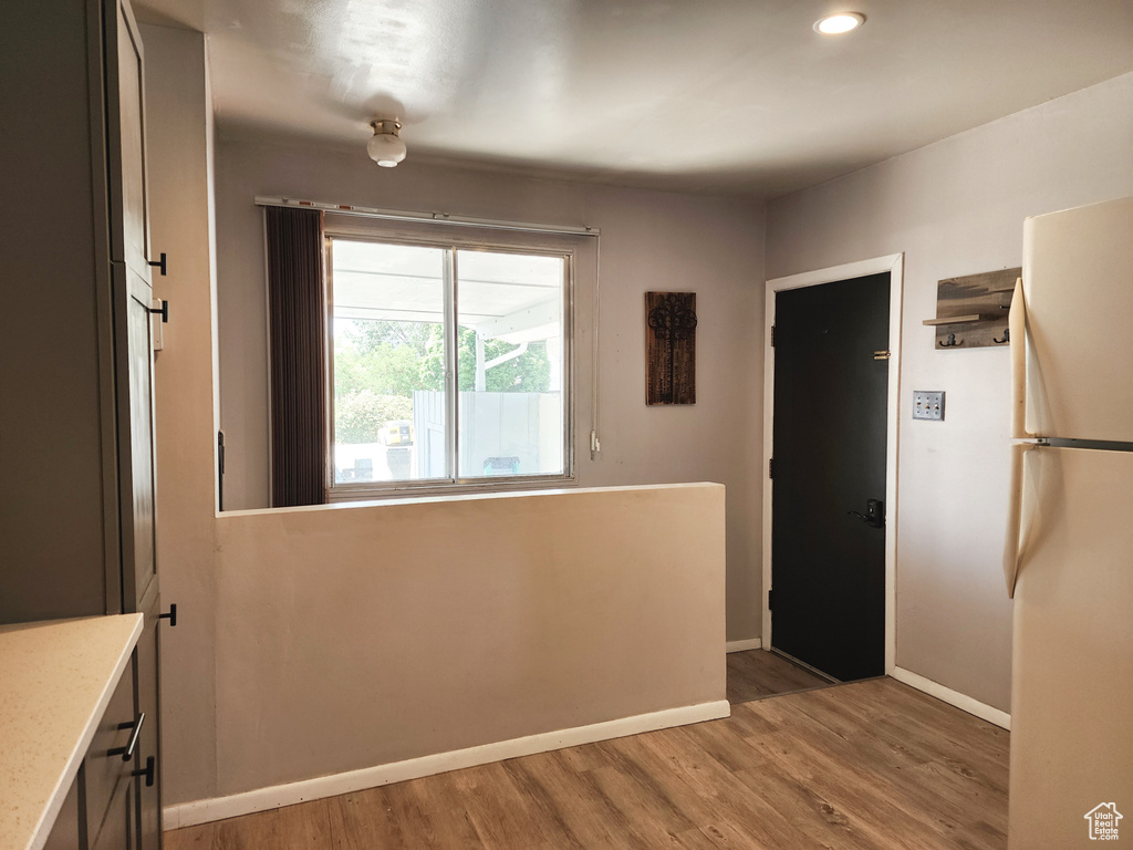 Kitchen with white refrigerator, wood-type flooring, and gray cabinets