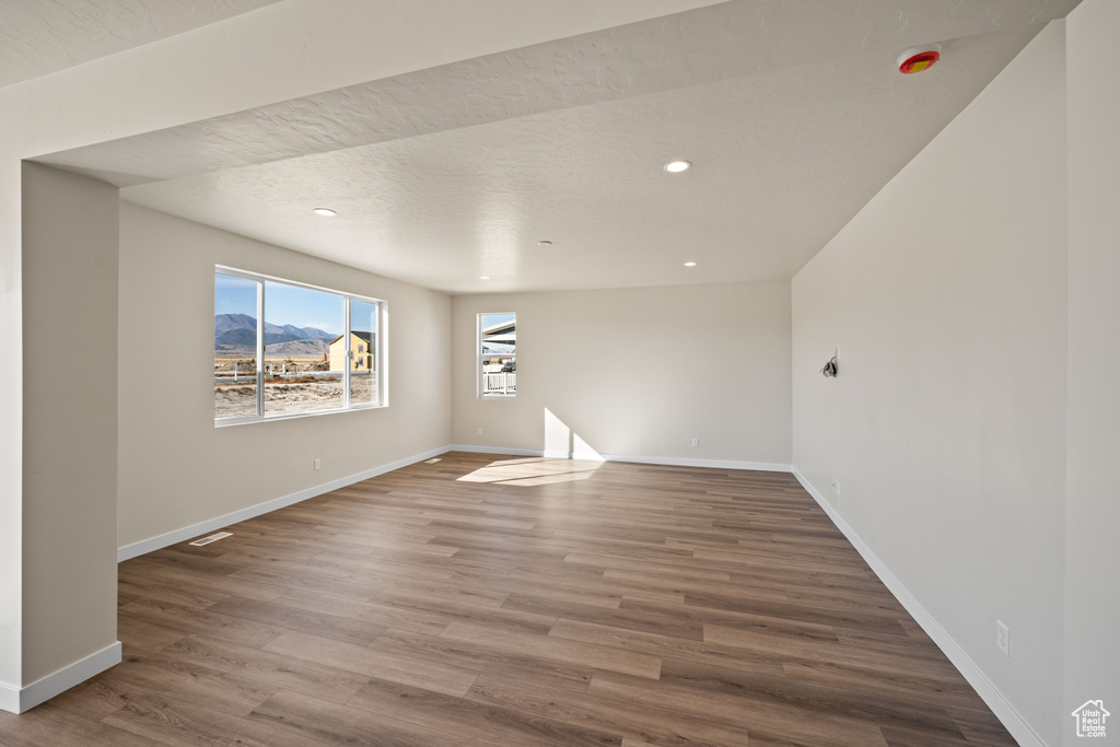 Unfurnished room featuring hardwood / wood-style flooring and a textured ceiling