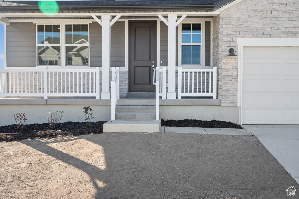 Doorway to property featuring a garage and covered porch