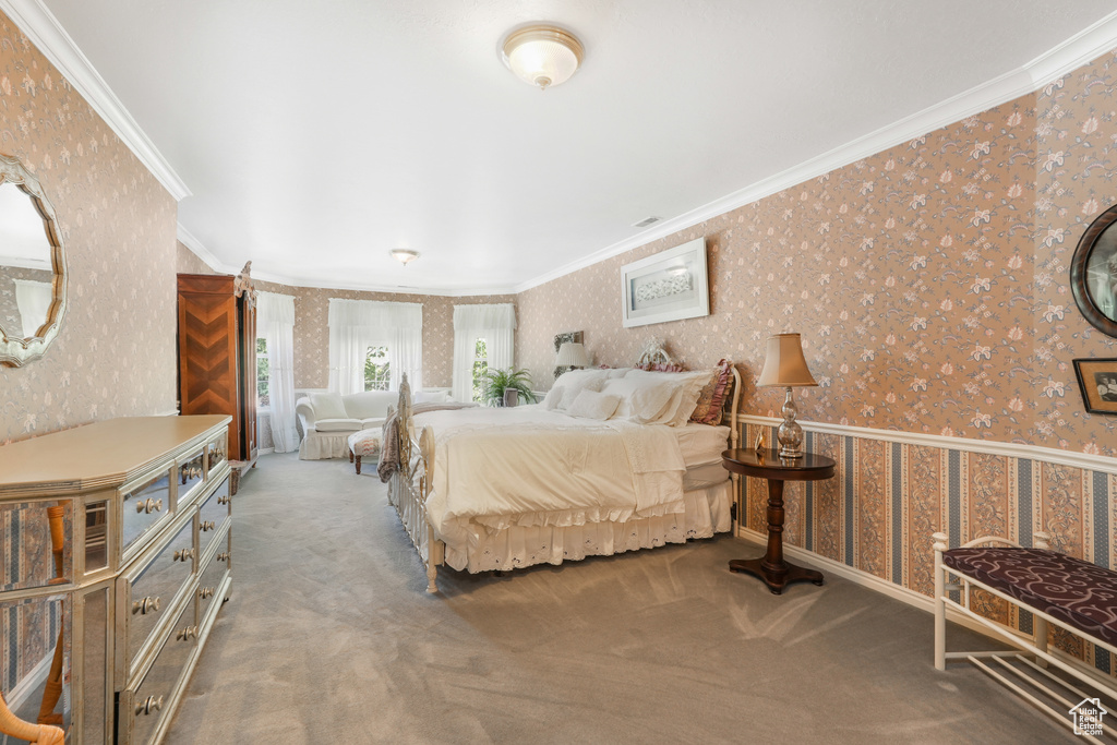 Carpeted bedroom featuring crown molding