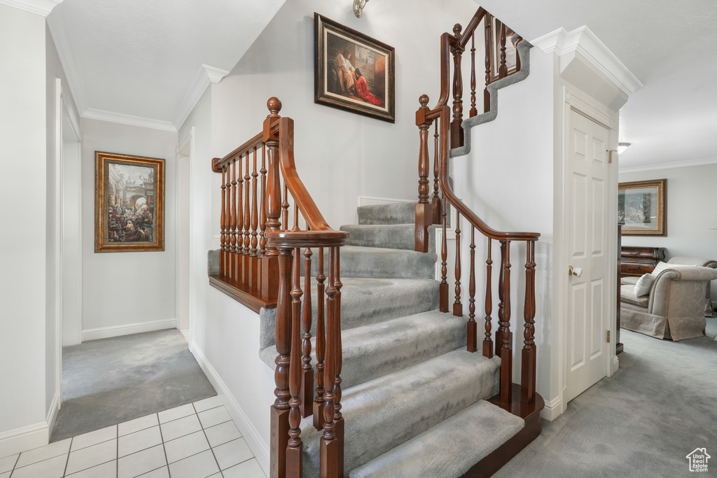 Stairway with tile floors and crown molding