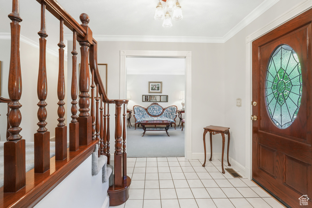 Entrance foyer featuring light tile flooring and crown molding