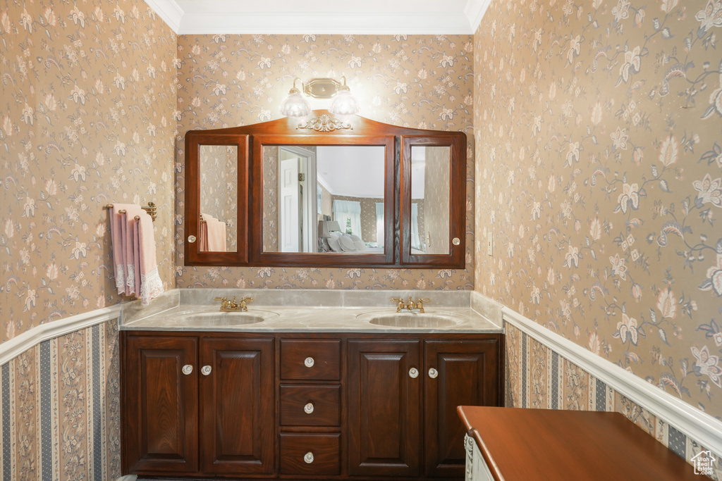 Bathroom featuring crown molding and dual bowl vanity