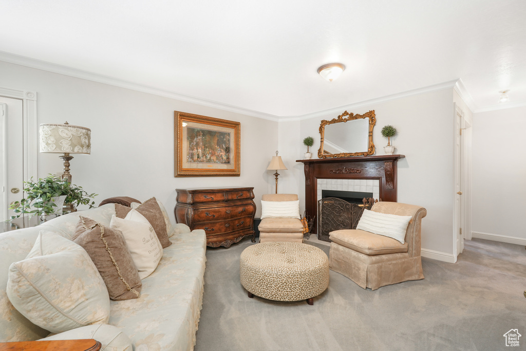 Living room featuring carpet flooring, a tiled fireplace, and ornamental molding