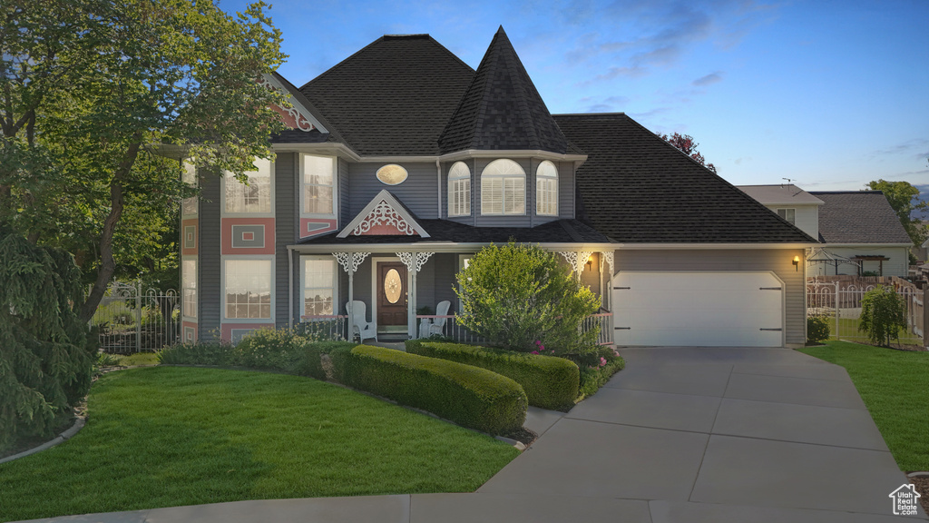 View of front of house with a garage and a yard