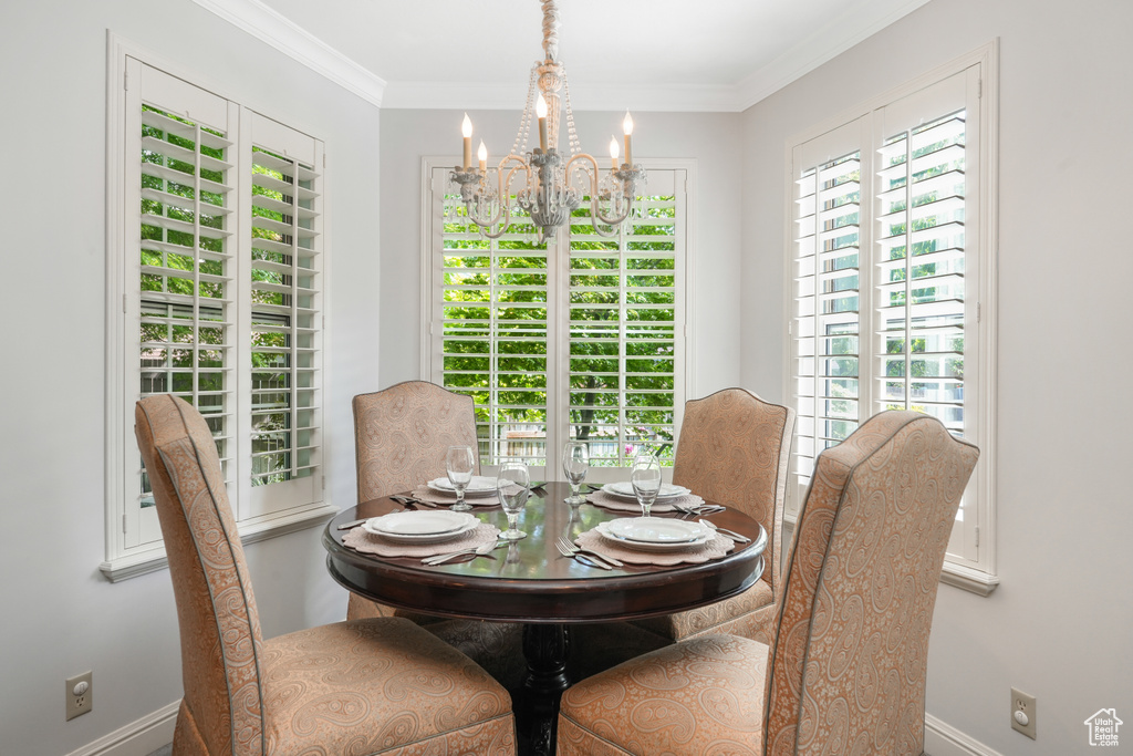 Dining space featuring plenty of natural light, an inviting chandelier, and crown molding