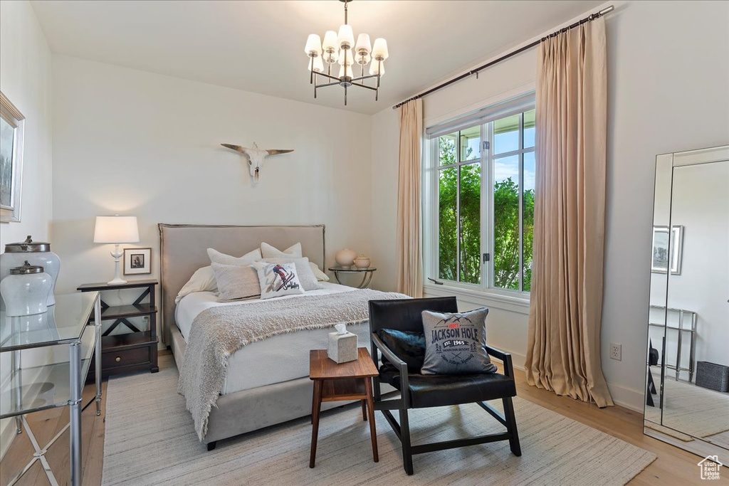 Bedroom featuring an inviting chandelier and light wood-type flooring