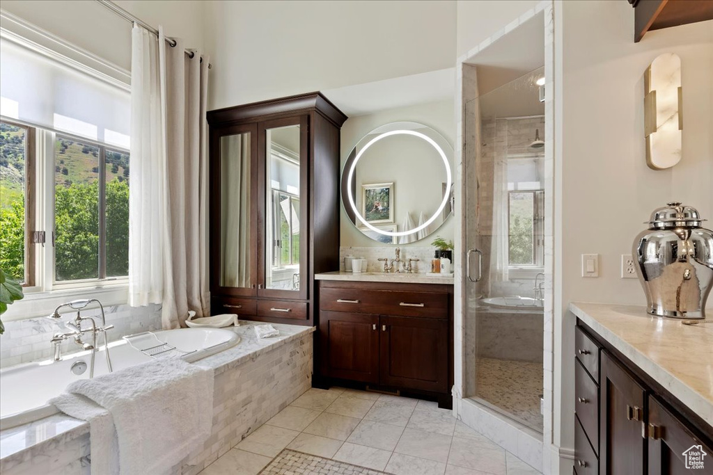 Bathroom featuring tile flooring, plenty of natural light, vanity, and plus walk in shower