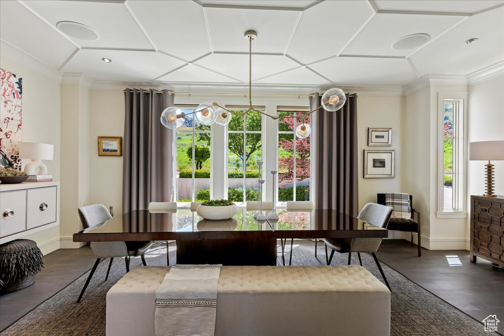 Dining space featuring ornamental molding, coffered ceiling, an inviting chandelier, and dark hardwood / wood-style flooring