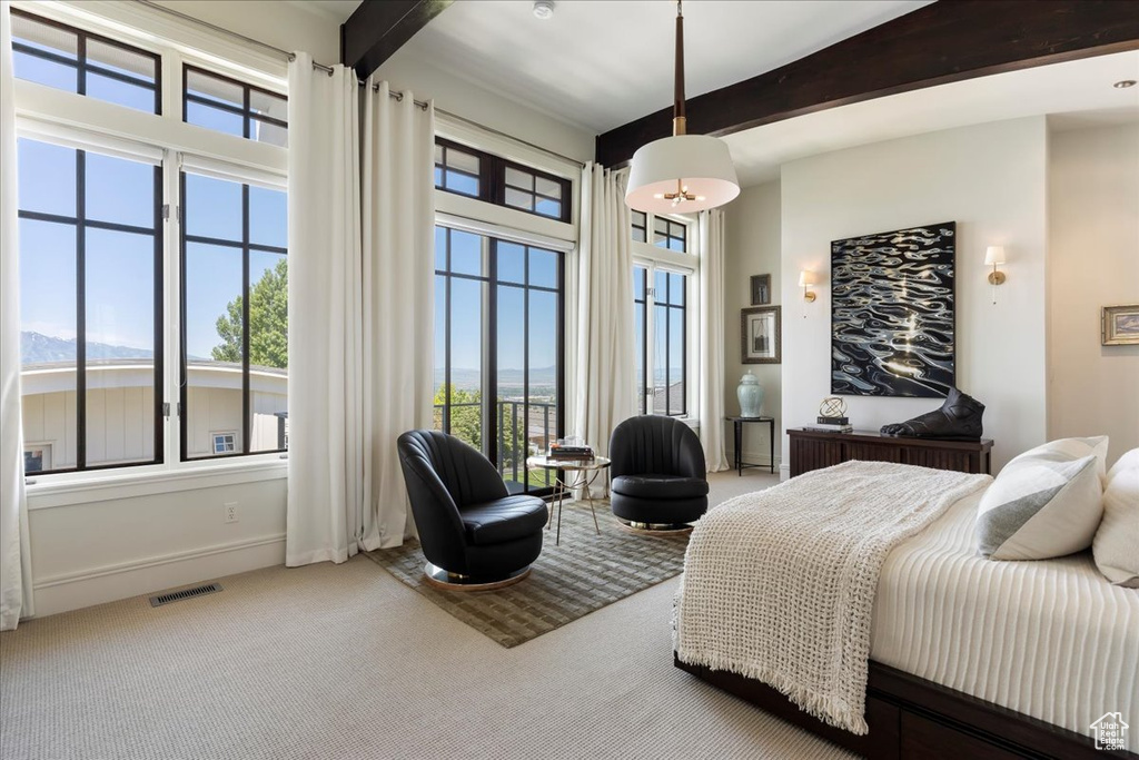 Carpeted bedroom featuring beam ceiling