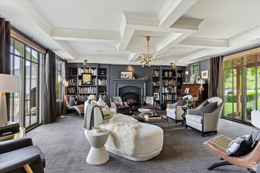 Carpeted living room with beamed ceiling, plenty of natural light, coffered ceiling, and crown molding