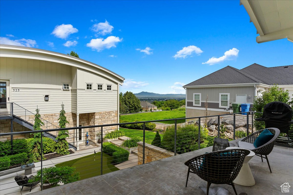 View of terrace with area for grilling, a balcony, and a mountain view