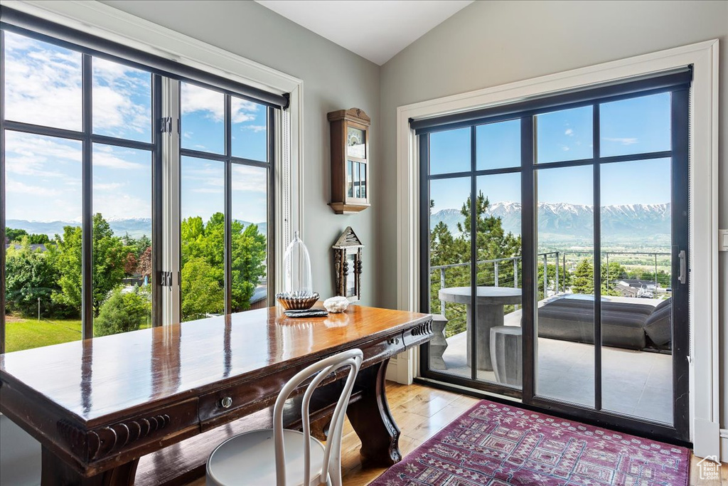 Dining space featuring a mountain view, light hardwood / wood-style flooring, and lofted ceiling