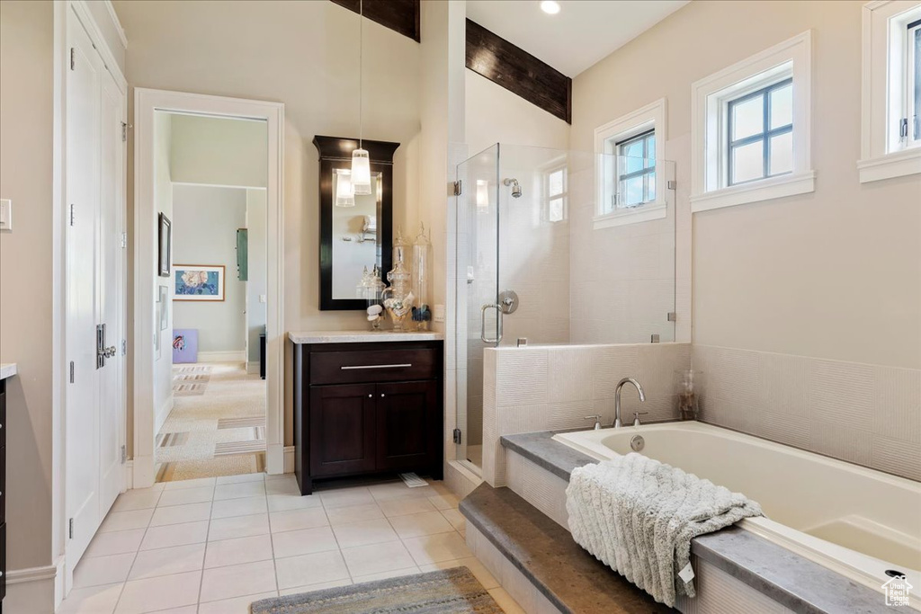 Bathroom featuring tile flooring, plus walk in shower, and vanity