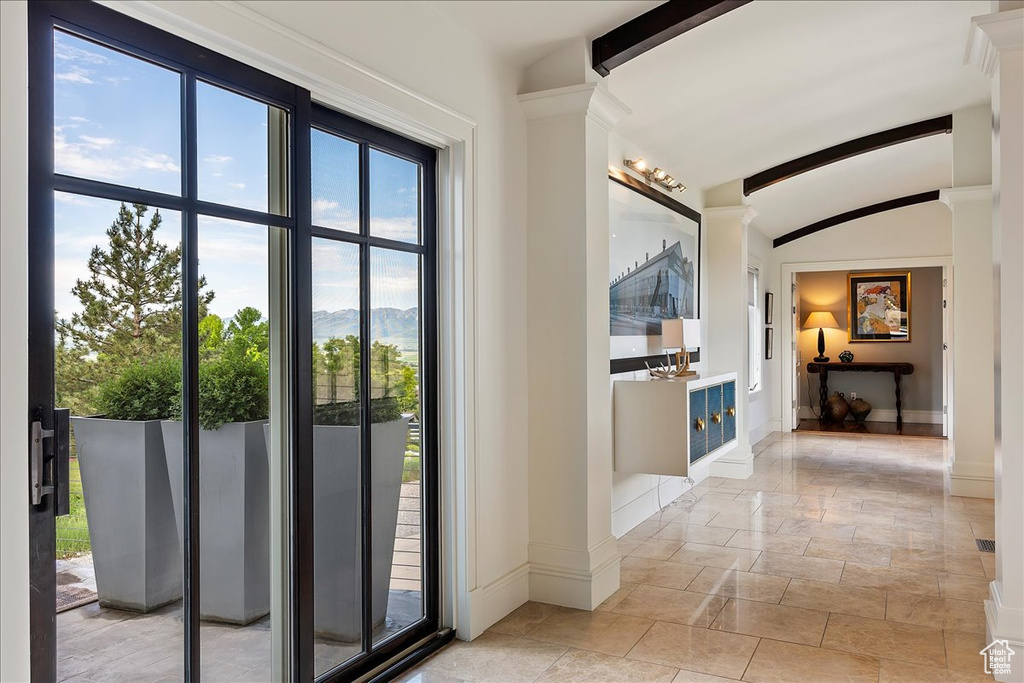 Entryway featuring lofted ceiling with beams and light tile floors